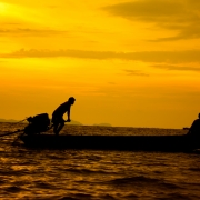 Fishermen going back home after sunset, life-style of coastal communities.