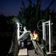 Surakit Laeaddee and his worker hold up a shrimp net at his shrimp farm in Leam Fa Pha, Thailand