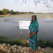 One of the cooperative members with one of the group's aquaculture pond