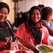 Women proudly show mangrove food products from their project.