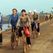 Women bike on the way home after collecting aquatic resources in Xuan Thuy National Park