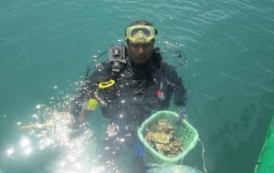 A local fisherman diver prepares to transplant corals in Bai Huong. 