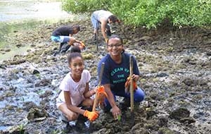 Student and teacher planting mangroves