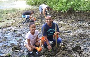 Student and teacher planting mangroves