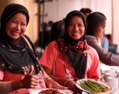 Women proudly show mangrove food products from their project.