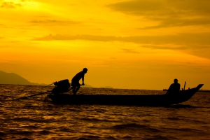 Fishermen going back home after sunset, life-style of coastal communities.