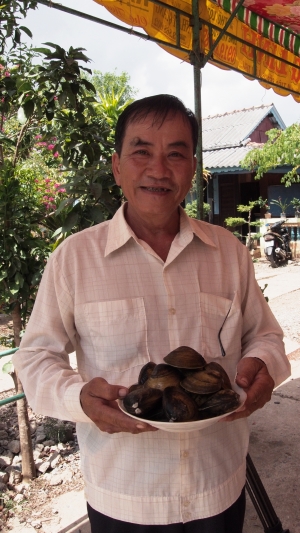 Bui Thanh Cong, shrimp farmer from Tra Vinh, Viet Nam, showing clams harvested from his farm.