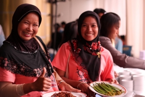 Women proudly show mangrove food products from their project.