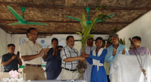 A student from Hnila Girl's High School accepts a sapling from Khursid Alam (CODEC) and Ishtiaq Uddin Ahmad (IUCN)