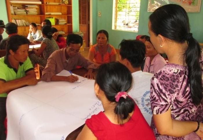 Mr. Sy (in green) participates in a meeting with local community members to deve